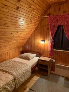 a bedroom with two beds in a wooden cabin at Chalet Hill Zabljak in Žabljak