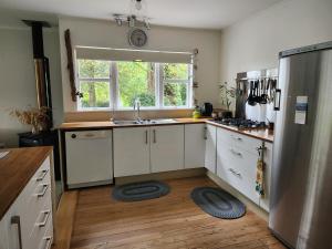 a kitchen with white cabinets and a sink and a window at La Petite Ferme Manor Kerikeri in Kerikeri
