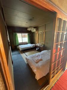 Habitación con vistas a un dormitorio con cama y ventana. en 高島市マキノ町民泊お得, en Takashima
