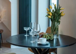 une table noire avec un vase de fleurs et des verres à vin dans l'établissement Apartament w sercu Wrocławia, garaż, 5min do Rynku, à Wrocław