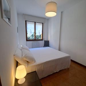 a bedroom with a bed with two lamps and a window at La casa di Camilla in Perledo
