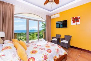 a bedroom with a bed and a large window at Casa Ilan Ilan in Playa Hermosa