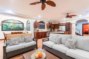 a living room with two couches and a kitchen at Casa Ilan Ilan in Playa Hermosa