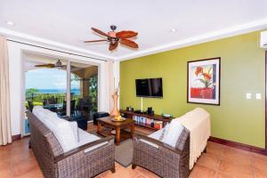 un soggiorno con divano, sedie e TV di Casa Ilan Ilan a Playa Hermosa