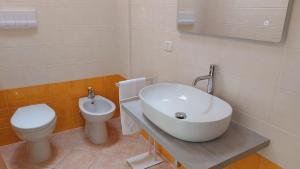 a bathroom with a sink and a toilet at Lovely House risveglio fronte mare in Marina di Pescoluse