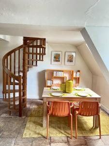 a dining room with a table and chairs and a staircase at Chaleureux duplex cosy in Caen