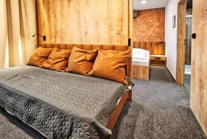 1 dormitorio con 1 cama con pared de madera en Restaurace a Penzion Praha en Dolní Dunajovice