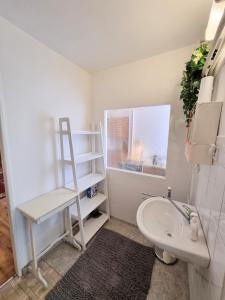 a white bathroom with a ladder and a sink at Apartment in a historical house in the center of Levoča in Levoča