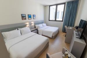 a hotel room with two beds and a window at Elements Hotel & Shops Curaçao in Willemstad