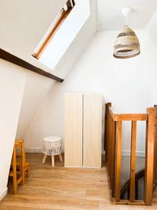a attic room with a cabinet and a light at Chaleureux duplex cosy in Caen