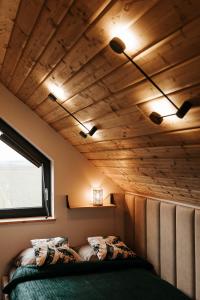 Cama en habitación con techo de madera en Okno Na Ślężę, 