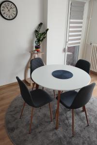 a white table and chairs in a room with a clock at La Vista in Loznica +4 photos