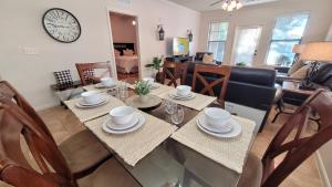 a dining room and living room with a table and chairs at Ground floor condo, no carpet, close to community pools, fitness room, 9 miles to Disney World in Davenport