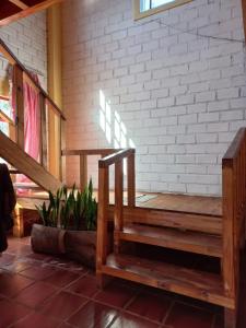 a porch with wooden stairs and a brick wall at La casona in Puerto Iguazú