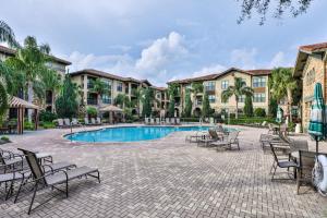 a courtyard with chairs and a swimming pool at a resort at Ground floor condo, no carpet, close to community pools, fitness room, 9 miles to Disney World in Davenport