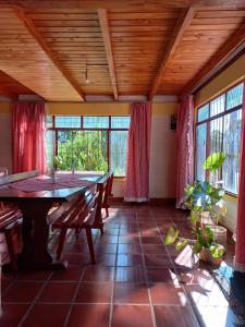 a dining room with a table and some windows at La casona in Puerto Iguazú
