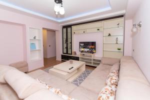 ein Wohnzimmer mit einem Sofa und einem TV in der Unterkunft Tirana Central Exclusive in Tirana