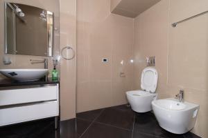 ein Badezimmer mit einem weißen WC und einem Waschbecken in der Unterkunft Tirana Central Exclusive in Tirana