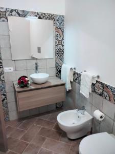 a bathroom with a sink and a toilet and a mirror at LA TERRAZZA in Ioppolo Giancaxio