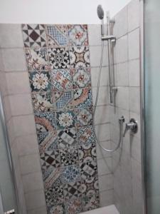 a bathroom with a shower with a tiled wall at LA TERRAZZA in Ioppolo Giancaxio