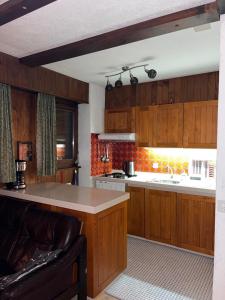 a kitchen with wooden cabinets and a counter top at Ischwarzsee in Plaffeien