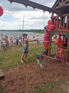 a group of people standing around a playground with a kite at dôme près du lac in Saint-Narcisse-de-Rimouski