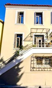 a large white building with windows and a balcony at Elia downtown eco house in Mytilene