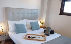 a white bed with a tray of flowers on it at Apartamentos Pirra - Aeropuerto Ifema in Madrid