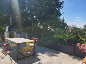 stół i krzesła na patio z kuchenką w obiekcie Maison schneid'family w mieście Jonage