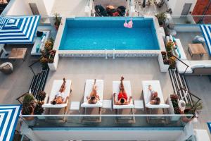 una vista aérea de la gente puesta en sillas en una piscina en Elements Hotel & Shops Curaçao en Willemstad