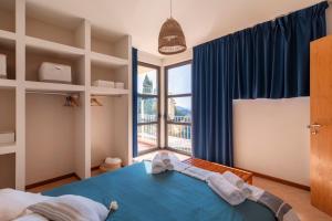 Un dormitorio con una cama azul y una ventana en Holiday Prato Verde, en Chiatri
