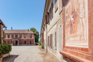 an alley with a building with a painting on it at Mahthildis Agriturismo B&B in Vermezzo