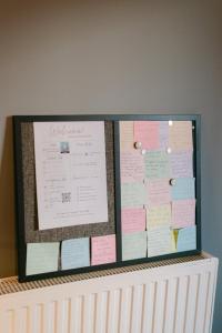 a bulletin board with notes on top of a crib at The Art Suite in Patra