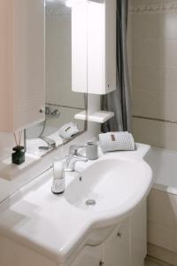 y baño con lavabo blanco y espejo. en The Art Suite en Patras