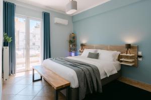 sypialnia z dużym łóżkiem i drewnianą ławką w obiekcie The Art Suite w mieście Patras