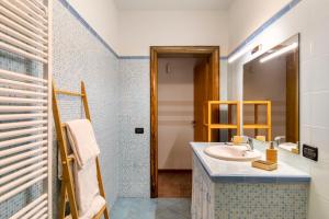 ein Bad mit einem Waschbecken und einem Spiegel in der Unterkunft Holiday Prato Verde in Chiatri