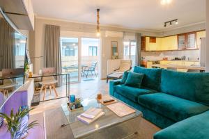a living room with a blue couch and a kitchen at The Art Suite in Patra