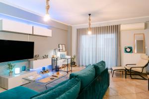 a living room with a green couch and a tv at The Art Suite in Patra