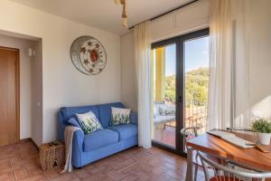 sala de estar con sofá azul, mesa y escritorio en Holiday Prato Verde, en Chiatri