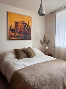 um quarto com uma cama com um quadro na parede em Departamento en ciudad cultural em San Salvador de Jujuy