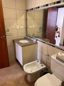 uma casa de banho com um WC, um lavatório e um espelho. em Departamento en ciudad cultural em San Salvador de Jujuy