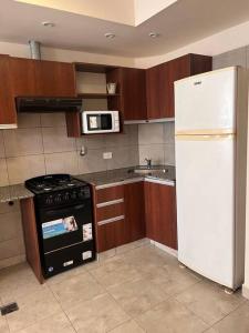 uma cozinha com um fogão e um frigorífico branco em Departamento en ciudad cultural em San Salvador de Jujuy