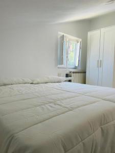 een groot wit bed in een witte slaapkamer bij Casa Lameiro in Lugo