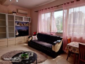 a living room with a black couch and a window at Relax Apartment 3 in Vlorë