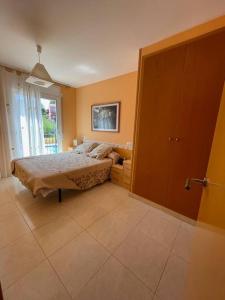 1 dormitorio con cama y ventana grande en Residencial Spiaggia Dorata a 100m de la Playa en Tarragona