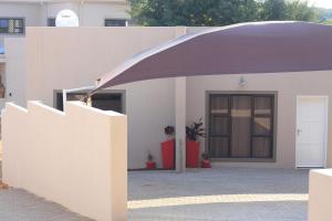 a white building with a purple canopy in front of it at Casa Decha in Windhoek