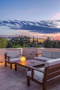 un patio con 2 sofás y una mesa con vistas en Suitas en Atenas