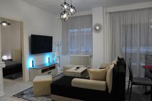 a living room with a couch and a flat screen tv at Poseidon's Premium Apartment in Katerini