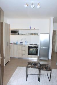 a kitchen with a stainless steel refrigerator and a table at Casa Decha in Windhoek