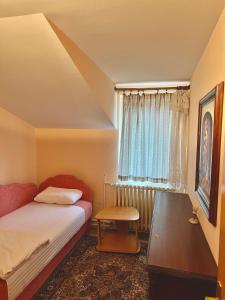 Schlafzimmer mit einem Bett, einem Tisch und einem Fenster in der Unterkunft WhiteHill house in Bukovac